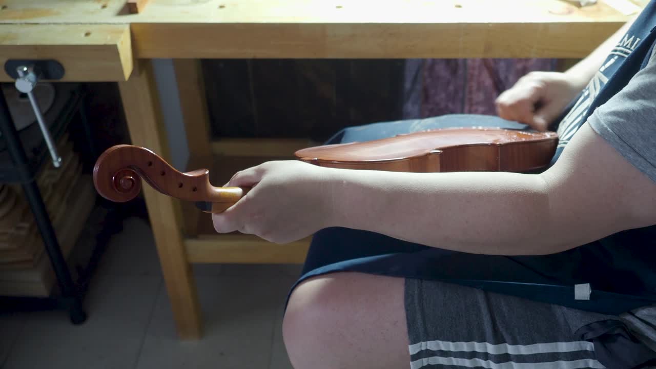 maestro de instrumentos de cuerda artesano luthier fabricante de violín violín antiguo placa trasera con tela y aceite cáustico ácido en nuevo instrumento de cuerda para reproducir modelos originales obra maestra de angustia