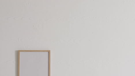 marco de madera con espacio de copia sobre un fondo blanco contra una pared blanca