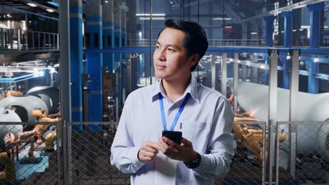 trabajador de una fábrica que usa un teléfono inteligente