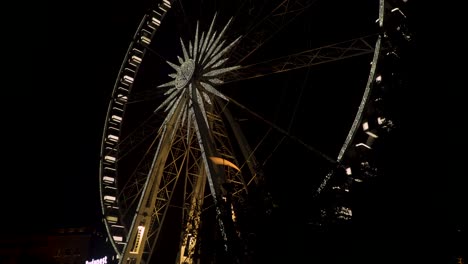 the budapest eye - large illuminated ferris wheel during nighttime - tilt down shot