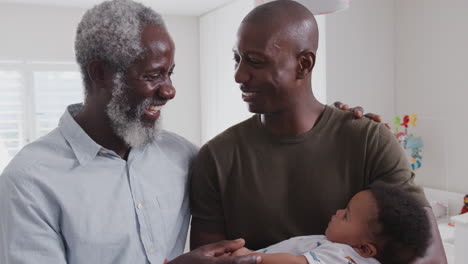 Orgulloso-Abuelo-Con-Un-Hijo-Adulto-Abrazando-A-Su-Nieto-En-La-Guardería-En-Casa