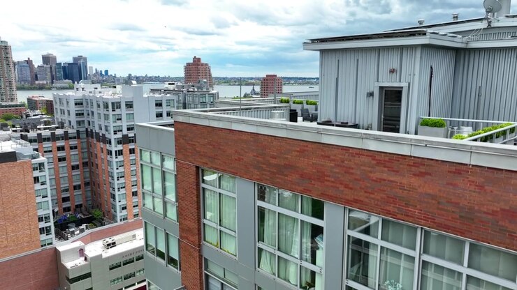 Ripresa aerea ravvicinata in ascesa di un complesso residenziale a molti piani nel centro di New York. Ripresa aerea di ambientazione di appartamenti a NYC