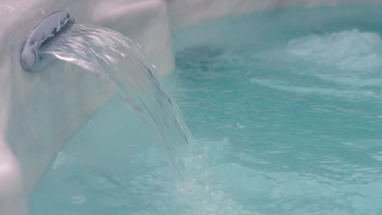 A current streams from a hot tub jet as the jacuzzi bubbles and froths.