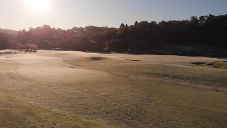 Backwards-aerial-drone-flight-over-sunny-golf-course-in-Kallered,-Molndal-in-Sweden