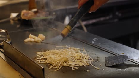 chef expertly grills meat and vegetables.