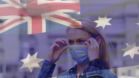 animation of flag of australia waving over caucasian woman wearing face mask in city street