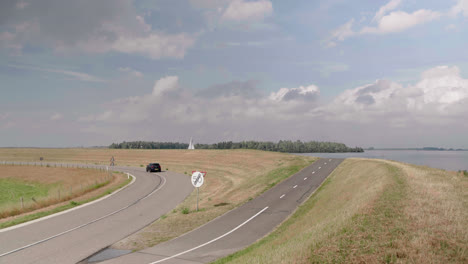 conducción de automóviles en una curva en una carretera de dique de pólder holandés