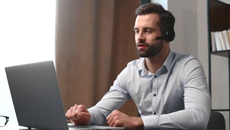 positive young handsome bearded man wearing headset