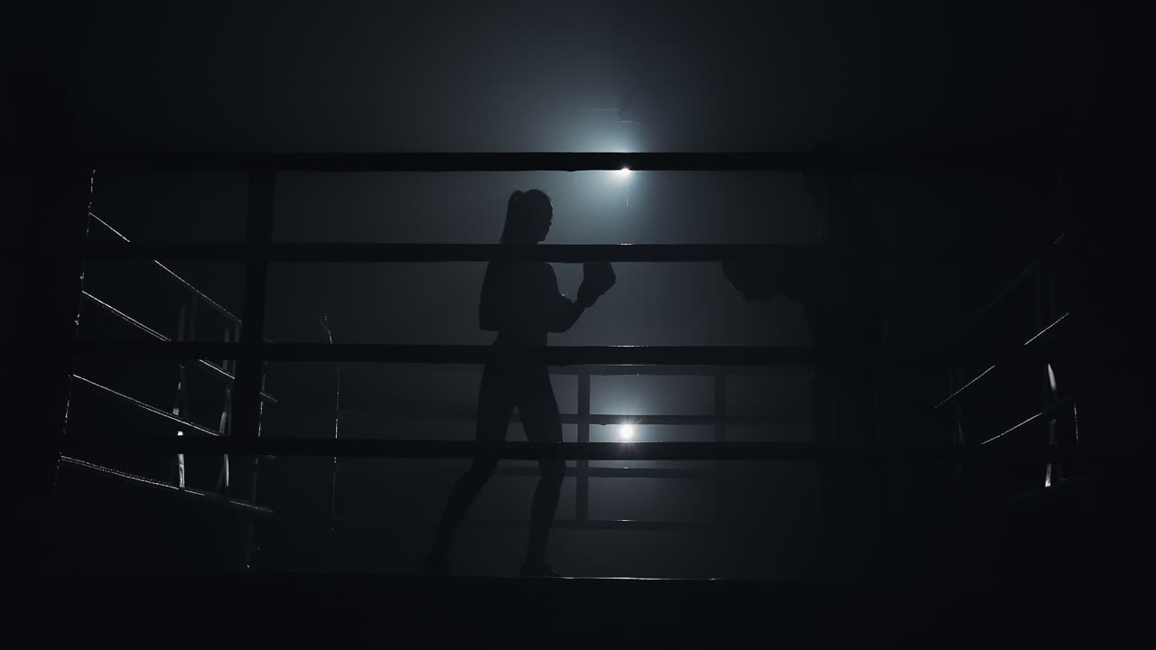 Silhouetted Boxers Training in a Dark, Smoky Ring