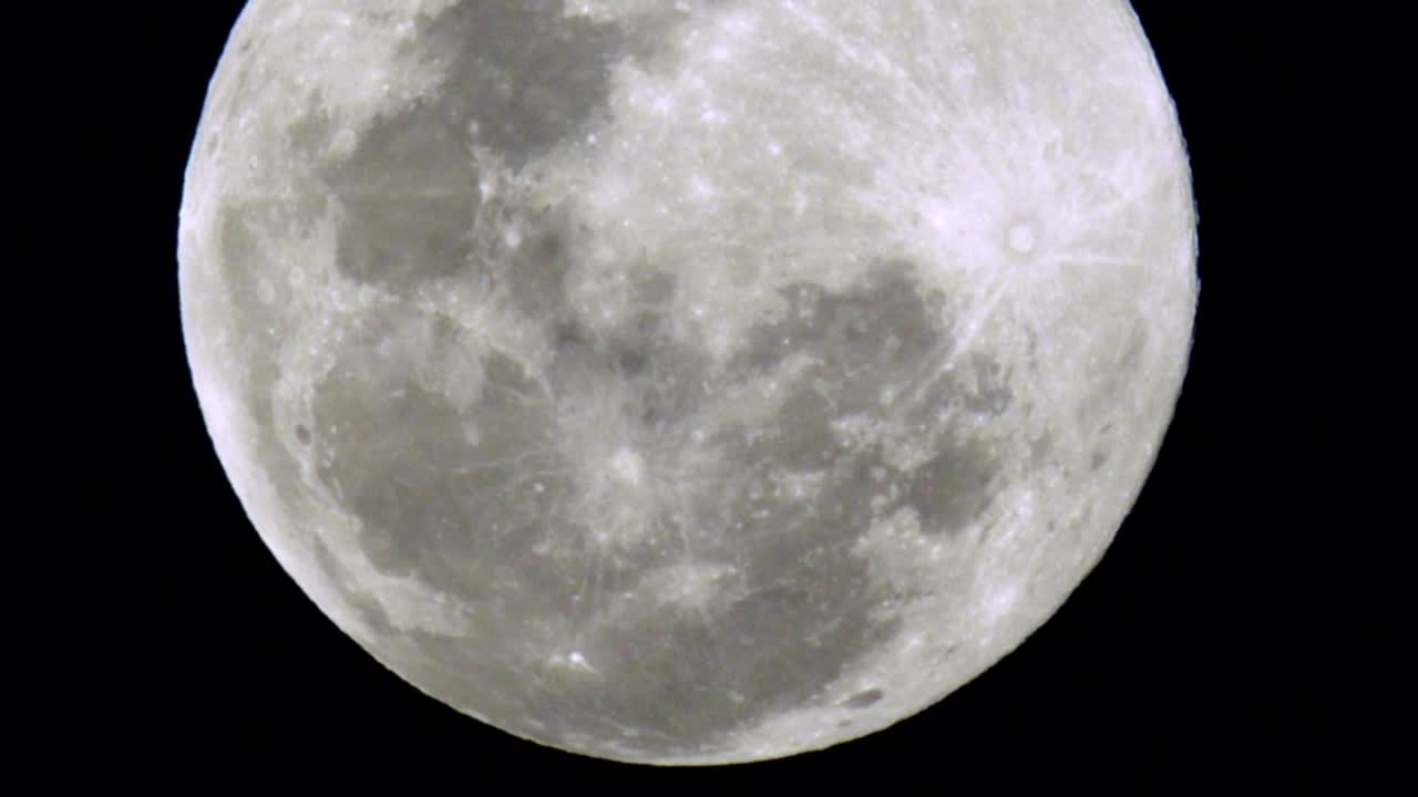 어두운 하늘에서 보름달이 뜨고 있습니다.