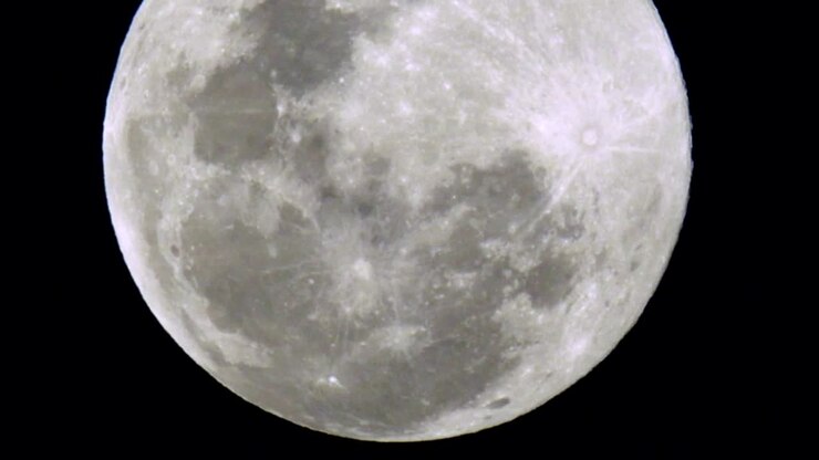 Lua cheia nascente em céu escuro