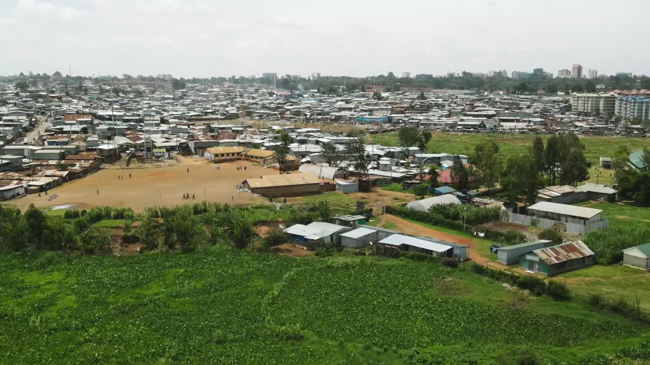 케냐 키베라 빈민가의 도시 풍경, 빈 축구장 주변에서 노는 가난한 가족, 키베라 케냐 빈민가의 인구 초과