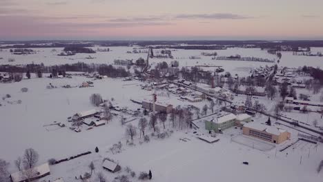 aerial drone view of countryside village in winter evening, sunset colors