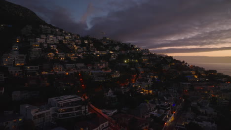 Dia-Und-Schwenk-Von-Luxusimmobilien-Am-Meer-In-Der-Abenddämmerung.-Fenster,-Die-Den-Bunten-Dämmerungshimmel-Reflektieren.-Kapstadt,-Süd-Afrika