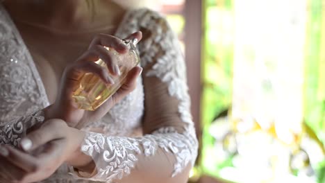 bride spraying perfume on her wrist