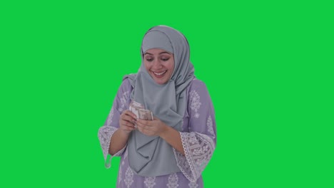 Happy-Muslim-woman-counting-money-Green-screen