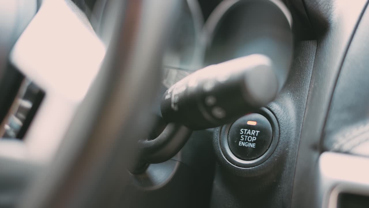 손가락으로 키 없는 자동차의 시동 버튼을 누르는 것