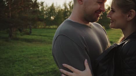 una pareja abrazándose en un parque al atardecer
