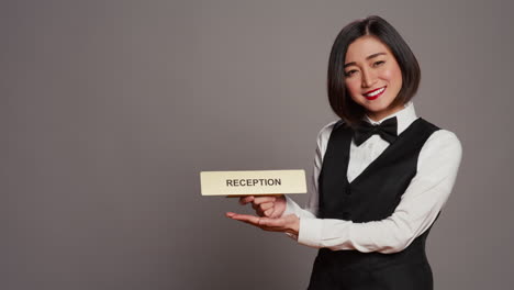 Hotel-Concierge-Mit-Schild,-Das-Die-Richtung-Zur-Rezeption-Anzeigt