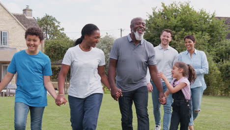 Mehrgenerationenfamilie-Mit-Gemischter-Rasse,-Die-Zu-Hause-Im-Garten-Spaziert