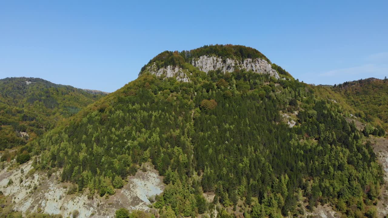 montaña rocosa con laderas cubiertas de árboles verdes en un soleado día de otoño en los balcanes