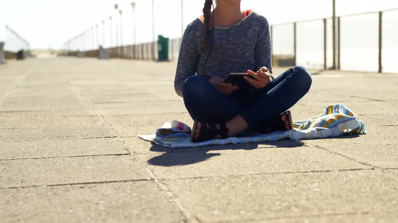 Ragazza che usa un tablet in spiaggia 4k