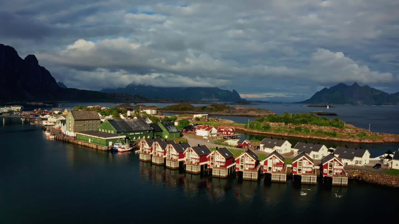 Aerial drone shot over Svolvaer, Lofoten Islands, Norway.
High view of the fishermen cabins and the scenic nordic landscape at sunset.