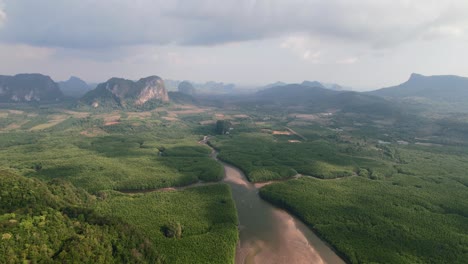 drone flying high over the mangroves and limestone mountains of ao thalane krabi thailand revealing the sandbar and river below during low tide