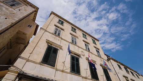 banderas frente a edificios antiguos en la famosa calle de stradun en dubrovnik, croacia