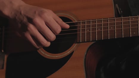 a handsome guy plays an acoustic guitar in an abandoned cinema. the musician sings a song and accompanies on the guitar