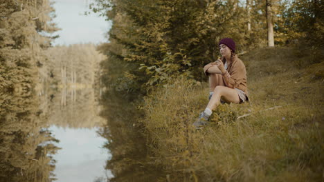 woman holding flower while sitting on grass