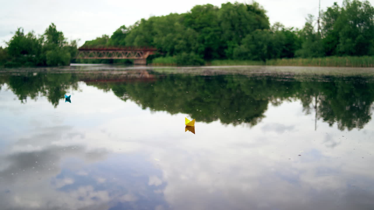 Toy boat of paper in the water. View of paper boat floating in the water
