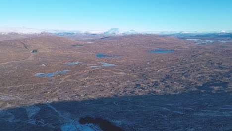 rugged landscape of skye with scattered lochs, under a clear blue sky, aerial view