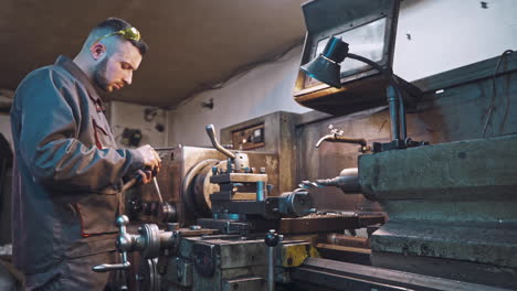 worker is measuring a produced detail by caliper.
