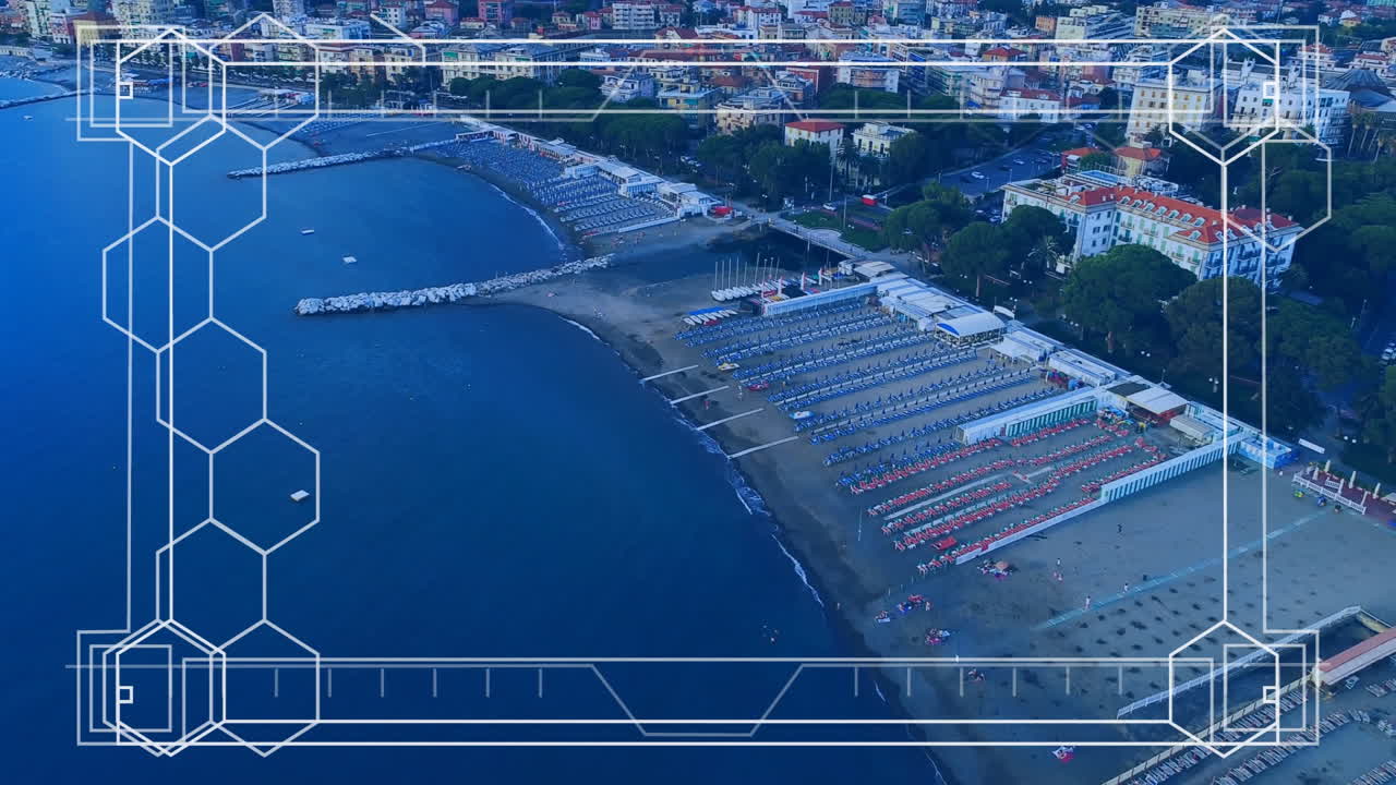 Coastal resort beach displaying sun lounger rows and umbrellas on sandy shore, showing hex overlay