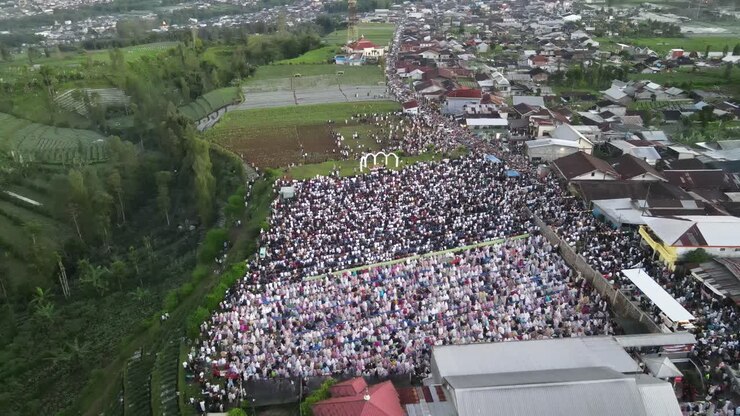 Aerial view, thousands of worshipers praying Eid al-Adha or Eid al-Fitr in Garung Village, Wonosobo. Praying with the most beautiful view of Mount Sumbing and Sindoro.