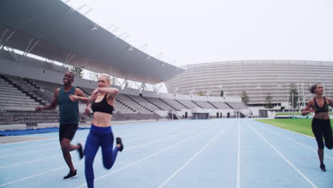 corredores cruzando la línea de meta en un estadio