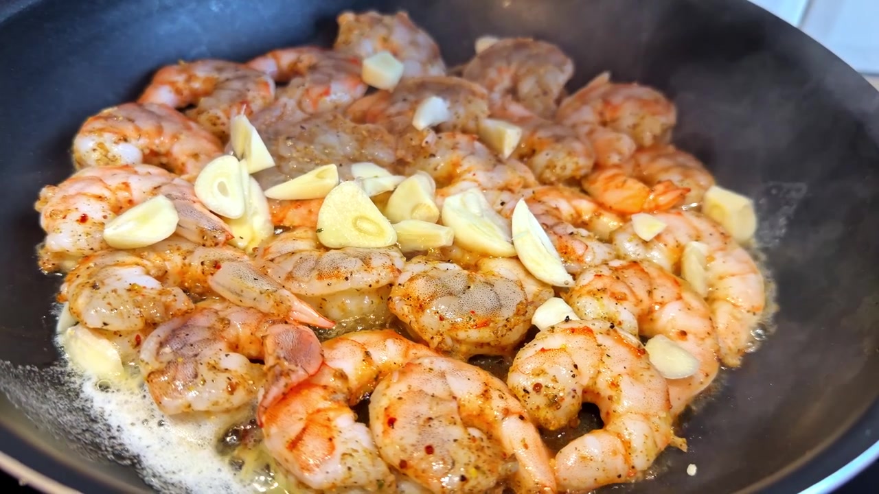 Delicious shrimp sautéing with garlic in a hot pan for a flavorful meal.