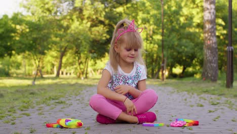 Child-girl-kid-playing-push-pop-it-bubble-squeeze-fidget-sensory-toys,-stress-anxiety-relief-game