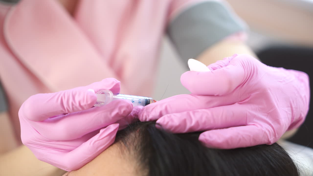 Handsome woman receives an injection in the head. The concept of mesotherapy. Thrust to strengthen the hair and their growth
