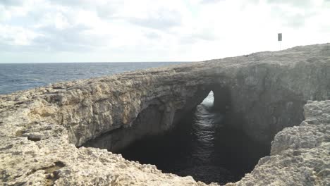 cueva de la laguna de coral con entrada visible al mar en un día ventoso en malta en invierno