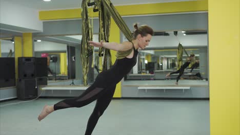 mujer practicando yoga aéreo