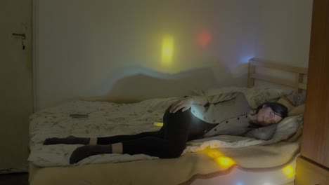 girl sleeping on bed with disco lights on zoom in