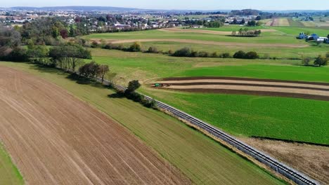 trabajadores agrícolas amish fertilizando orgánicamente sus campos vistos por un dron