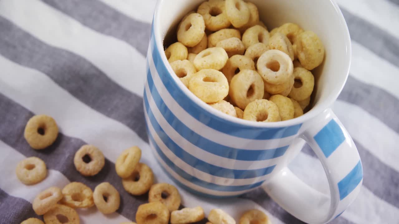 Anelli di cereali versati in una tazza 4k