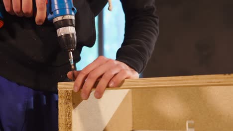 carpenter assembling a wooden cabinet