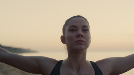 closeup yoga woman training on sandy beach. girl raising up hands on nature.