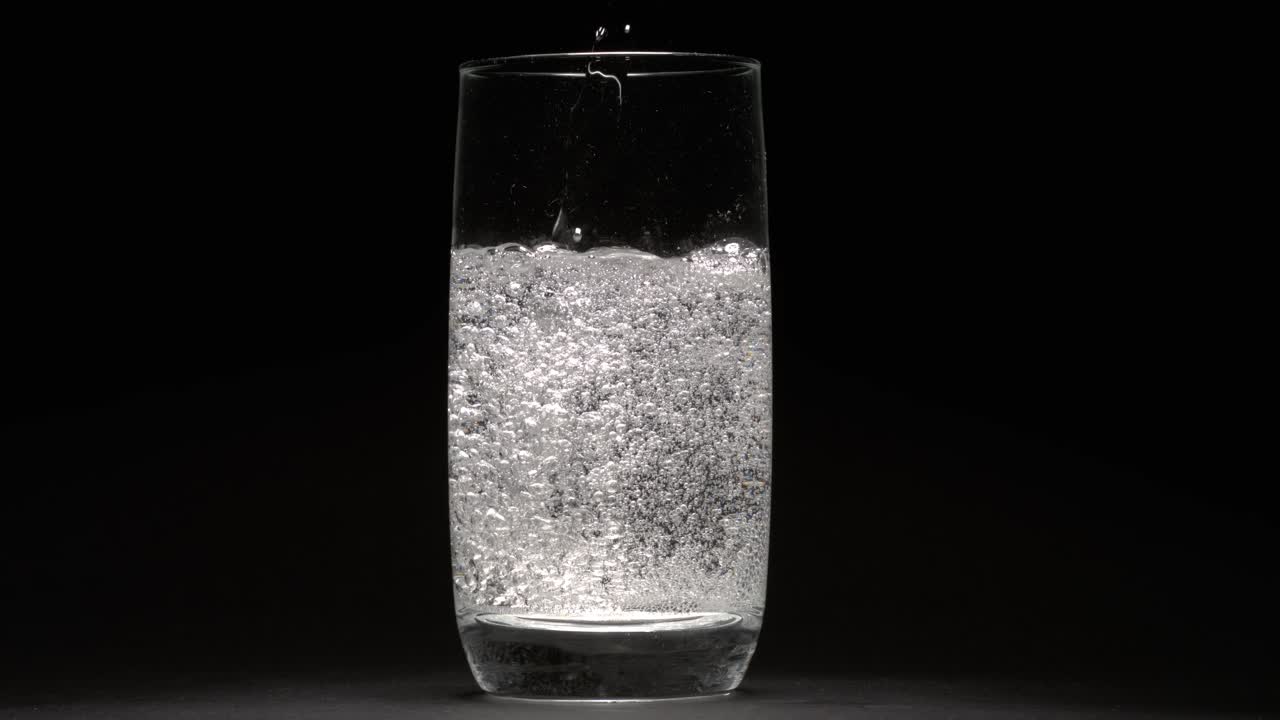 Acqua minerale effervescente nel bicchiere. Girato con telecamera super slow motion a 1000 fps