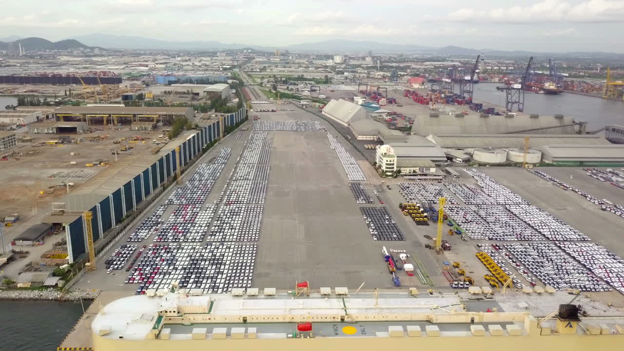 vista aérea del concepto de logística de vehículos comerciales, automóviles y camionetas que esperan ser cargados en un buque de transporte de automóviles rodante