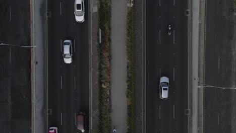 Aerial-Descending-Shot-Over-Traffic-Driving-Past-On-Highway-In-Mexico-City